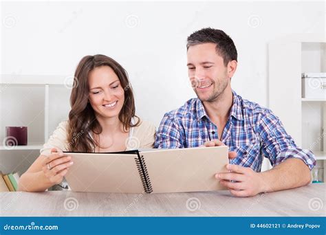 happy couple looking at photo album stock image image of look emotion 44602121