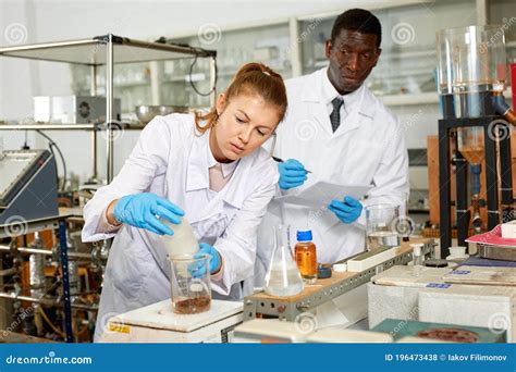 Focused Lab Technician Woman With Tubes And Worried Man Technician