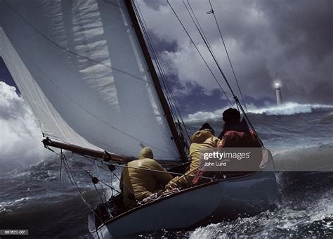 Sailboat In Stormy Seas Lighthouse In Distance Stock Foto Getty Images