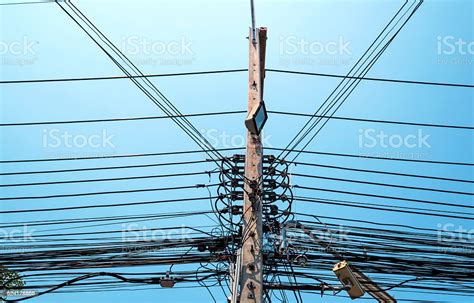 Electricity Pole With Messy Electrical Cables And Street Light Stock