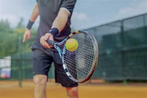 Close Up Of Man Playing Tennis At Court And Beating The Ball With A