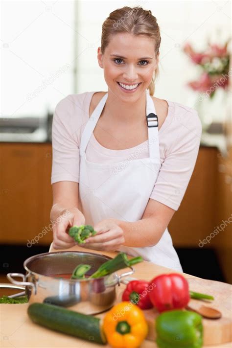 Portrait Of A Smiling Woman Cooking — Stock Photo © Wavebreakmedia