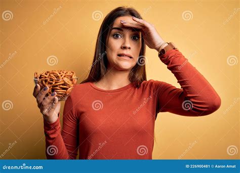 Young Beautiful Brunette Woman Holding Bowl With Germany Baked Pretzels Stressed With Hand On