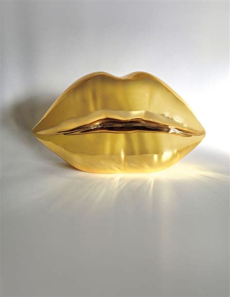 A Golden Lip Shaped Object Sitting On Top Of A White Surface