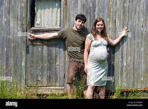 Husband With Pregnant Wife In Front Of Their Old House Stock Photo Alamy