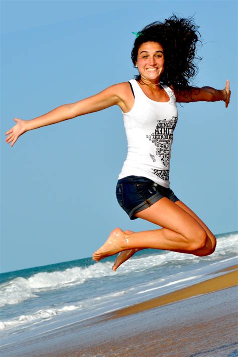 Things to say to your girlfriend to make her happy. Girl on a beach wearing denim shorts and white top while ...