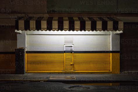 Closed Shutter Of Store At Night Stock Photo