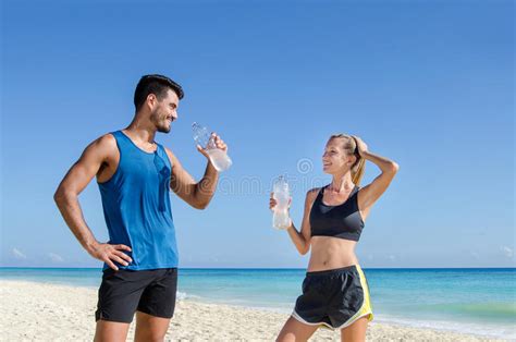 Fitness Couple Drink Water After Training At The Beach