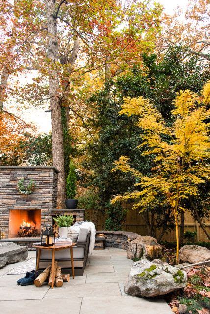 An Outdoor Fireplace In The Middle Of A Patio Surrounded By Rocks And