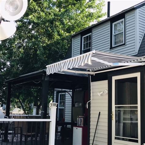 A Small House With An Awning Over The Front Door And Patio Area Next To It