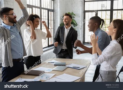 Excited Diverse Employees Celebrating Great Teamwork Stock Photo