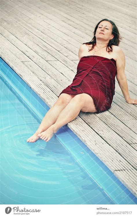 Reife Brünette Frau Sonnt Sich Am Pool Mit Den Füßen Im Wasser In Ein