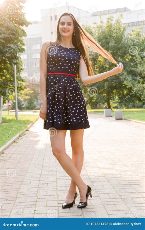 Young Beautiful Attractive Woman In A Stylish Dress Posing On Camera She Laughs Poses For