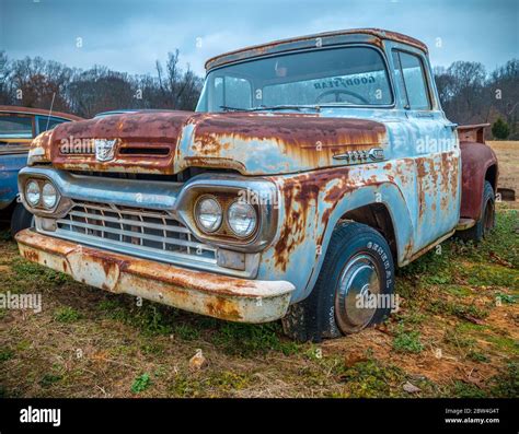 A Ford F100 Antique Pickup Truck Parked In A Farm Field Along The