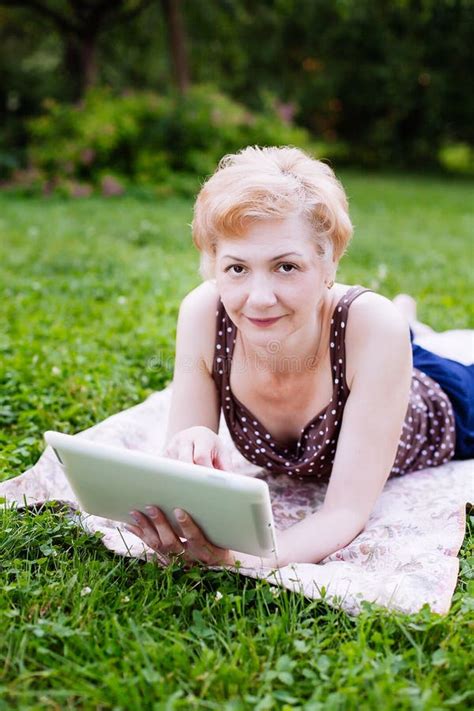 portrait of middle aged woman using tablet in the park stock image image of aged adult 75199229