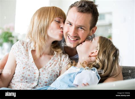 Familia Feliz Sentado En El Sofá Madre E Hija Besos Padre Fotografía