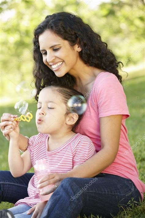 Mother And Daughter Blowing Bubbles Stock Photo By ©monkeybusiness