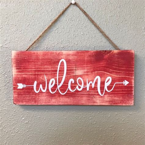 A Wooden Sign That Says Welcome Hanging On A Wall
