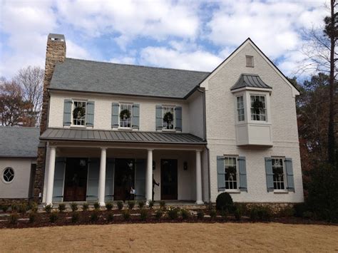 Lanterns, painted brick, metal doors in black, herringbone brick and boxwood. Atlanta Homes | Atlanta homes, White brick houses, Painted ...