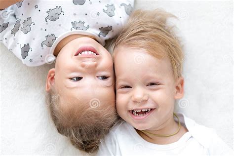 Three Little Smiling Kids Play Together On Bed Happy Brother And