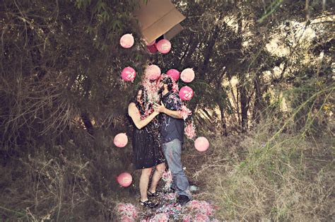 A Man And Woman Standing In The Grass With Pink Flowers On Their Head