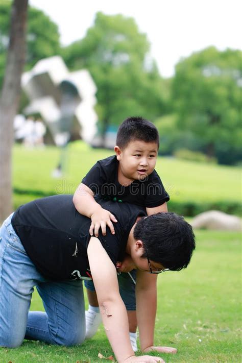 Padre Asiático E Hijo Que Se Divierten En Parque Imagen De Archivo