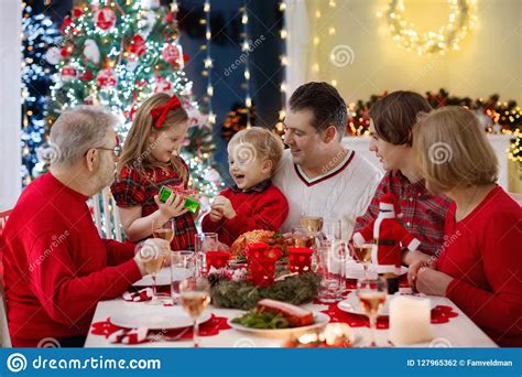 Christmas is approaching and magic is in the air. Family With Kids Having Christmas Dinner At Tree Stock Photo - Image of grandparents, family ...