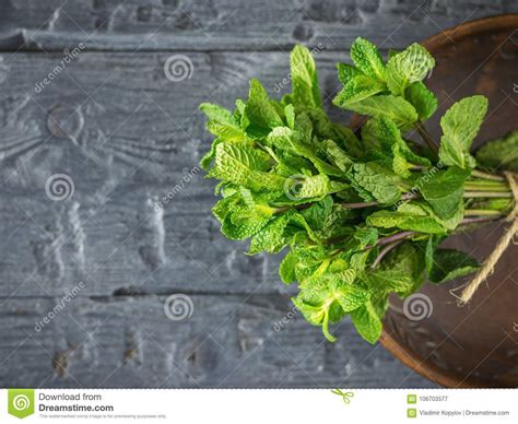 A Bundle Of Mint In A Clay Bowl On A Wooden Table The Concept Of