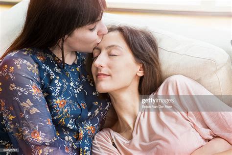 Woman Kisses Girlfriend On Forehead On Sofa Photo Getty Images
