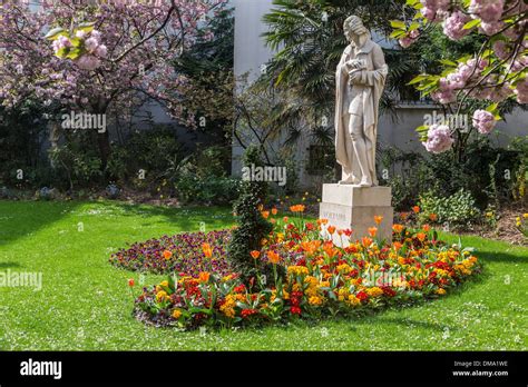 Statue Of Voltaire In The Middle Of A Flowering Garden Rue De Seine