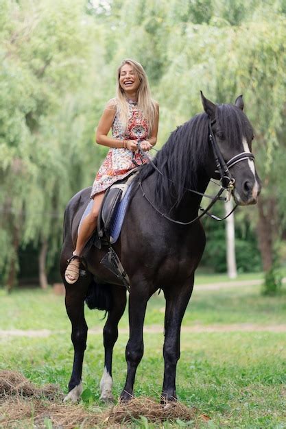 Free Photo Young Woman In A Bright Colorful Dress Riding A Black Horse