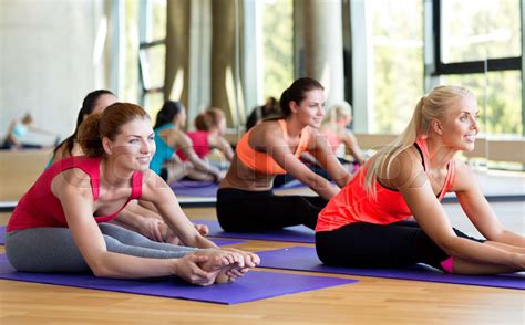 group of smiling women stretching in gym stock image colourbox