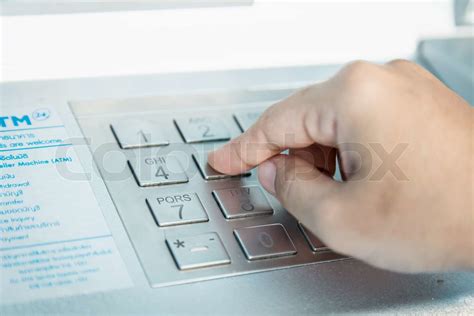 Close Up Of Hand Entering Pinpass Code On Atmbank Machine Keypad