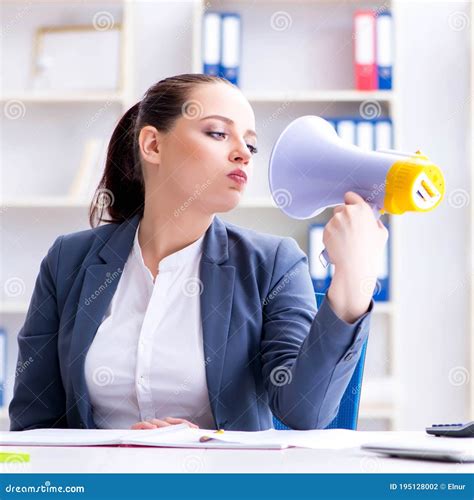 The Angry Businesswoman Yelling With Loudspeaker In Office Stock Photo