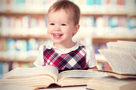 Happy Baby Girl Reading A Book In A Library Stock Photo Image Of