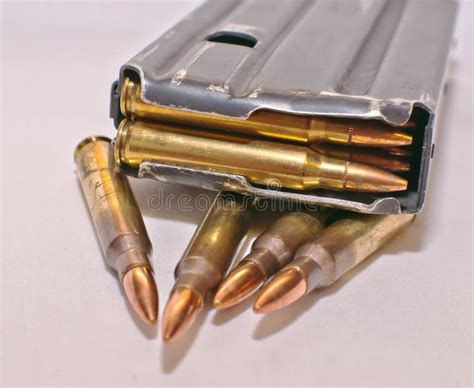 A Loaded Ar 15 Rifle Magazine On Top Of Four 223 Caliber Bullets Stock