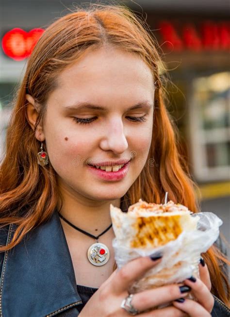 Joven Adolescente Pelirroja Con Pelo Largo Comiendo Shawarma De Pollo En La Calle Imagen De