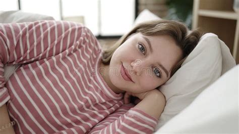 Young Blonde Woman Smiling Confident Lying On Bed At Bedroom Stock