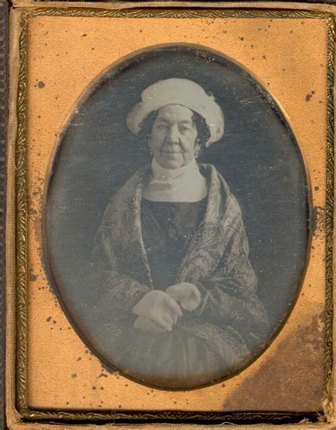 An Old Photo Of A Woman Wearing A White Hat And Holding Her Hand Out To
