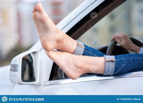 Close Up Of Woman Driver Bare Feet Sticking Out Of A Car Open Window