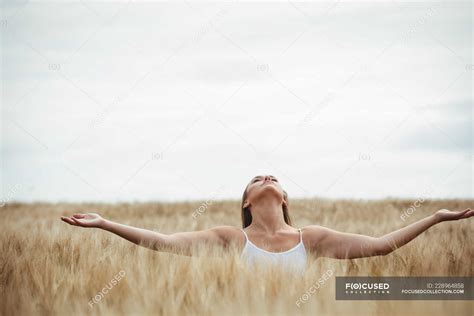 Woman Standing With Outstretched Arms In Field — Casual Clothing Calm
