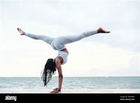 Side View Of Athletic Young Woman Practicing Yoga Doing Handstand With