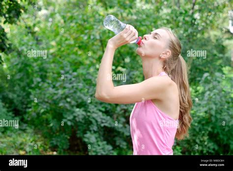Sporty Young Woman Drinking Water From The Bottle Doing Sport Outdoor