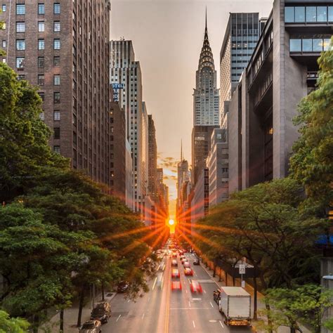 New york city street sunset and reflection off the side walk/pavement and building wall. Sunset burst over Manhattan's 42nd Street from the Tudor ...