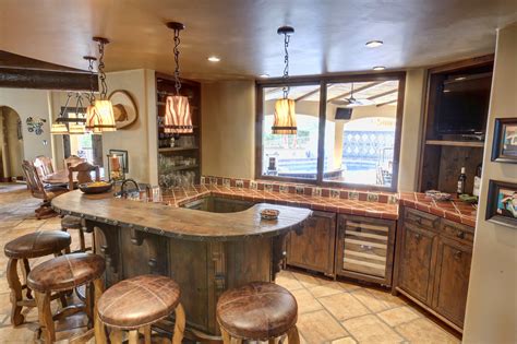 It faces a glass coffee table surrounded with a white sectional sofa, wooden bar stools, a woven bean bag and a chair covered with a throw blanket. 18 Seductive Mediterranean Home Bar Designs For Leisure In ...