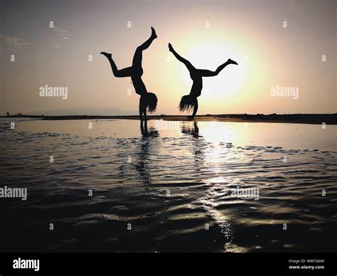 Silhouette Young Women Practicing Handstand On Shore Stock Photo Alamy