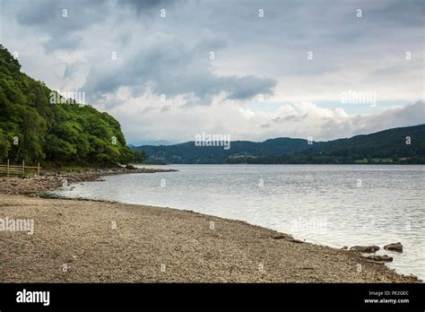 An Image Of The Shoreline And Dramatic Sky At Coniston Water Lake