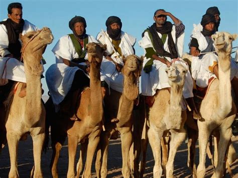 Several Men Riding Camels In The Desert