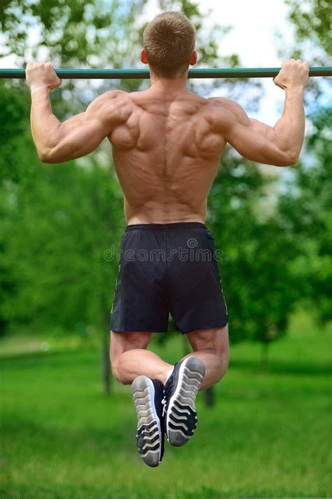 Handsome Muscular Bodybuilder Man Doing Exercises In Gym Stock Photo