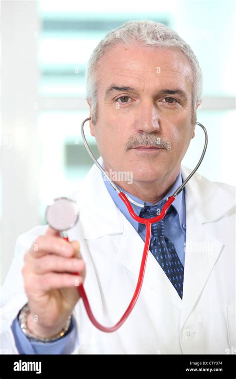 Doctor Holding Up The Chestpiece Of His Stethoscope Stock Photo Alamy